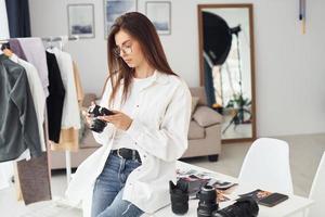 fotógrafo feminino em roupas casuais está trabalhando dentro de casa durante o dia foto