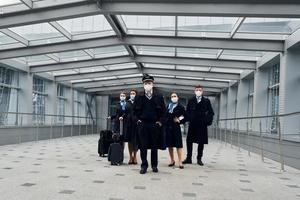 tripulação de avião de uniforme vai trabalhar juntos foto