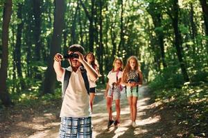 natureza bela. crianças passeando na floresta com equipamentos de viagem foto