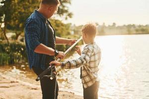 pai e filho pescando juntos ao ar livre no verão foto