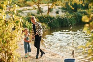 menino com sua irmã na pesca ao ar livre no verão juntos foto