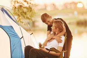 filho abraçando sua mãe perto da tenda ao ar livre foto