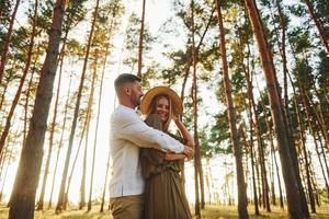 passar o tempo do fim de semana. casal feliz está ao ar livre na floresta durante o dia foto