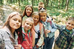 fazendo selfie. crianças na floresta verde durante o dia de verão juntos foto