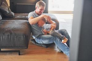 ter tempo livre. pai e filho está dentro de casa juntos foto