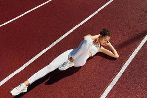 fazendo abdominais. jovem em roupas esportivas está se exercitando ao ar livre foto