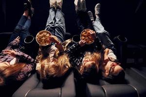 deliciosa pipoca. grupo de crianças sentadas no cinema e assistindo filme juntos foto