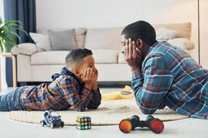 jogando juntos. pai afro-americano com seu filho em casa foto