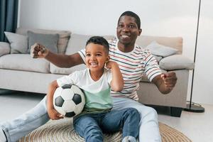 entretenimento para as pessoas. pai afro-americano com seu filho em casa foto