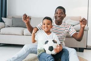 entretenimento para as pessoas. pai afro-americano com seu filho em casa foto