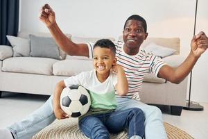 entretenimento para as pessoas. pai afro-americano com seu filho em casa foto