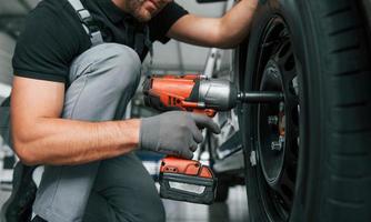 veículo moderno. homem de uniforme está trabalhando no autosalon durante o dia foto