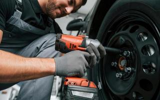 veículo moderno. homem de uniforme está trabalhando no autosalon durante o dia foto