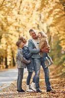 perto da estrada. família feliz está no parque no outono juntos foto