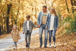 quatro pessoas. família feliz está no parque no outono juntos foto