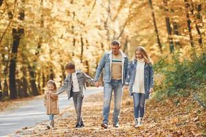 pessoas alegres. família feliz está no parque no outono juntos foto