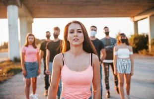 mulher na frente da multidão. grupo de jovens protestantes que estão juntos. ativista pelos direitos humanos ou contra o governo foto