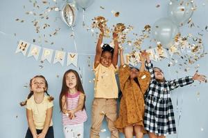 balões e confetes. as crianças comemorando a festa de aniversário dentro de casa se divertem juntas foto