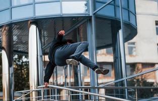 jovem fazendo parkour na cidade durante o dia. concepção de esportes radicais foto