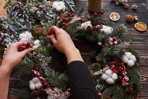 mãos cuidando do ornamento. vista superior do quadro festivo de natal com decorações de ano novo foto