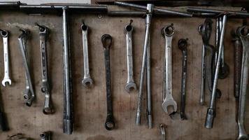 muitas ferramentas penduradas em uma parede de madeira. conjunto de ferramentas foto