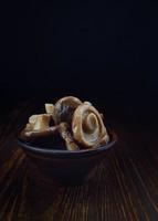 deliciosos belos cogumelos em conserva em um copo de barro sobre uma mesa de madeira. cogumelos salgados . comida rústica. foto