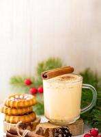 imagem vertical de natal com foco suave com sobremesas tradicionais gemada na xícara e biscoitos de gengibre. foto