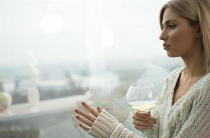 mulheres loiras atraentes bebendo vinho por uma janela. foto