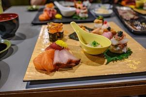 conjunto de sushi e sashimi na placa de madeira no restaurante japonês. foto