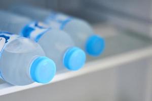 garrafas com água fria na geladeira, closeup foto