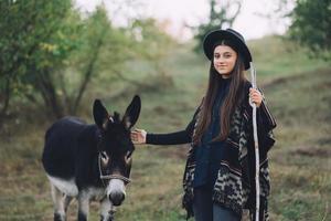 mulher jovem feliz viajando com burro na natureza foto