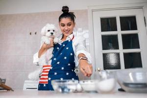 mulher apontando o dedo na cozinha enquanto segura cachorro maltês foto