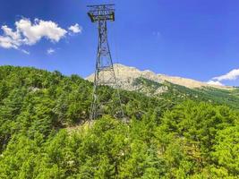 teleférico na montanha. vista de uma altura de plantas exóticas verdes. linha de energia fornece a estrada com energia foto