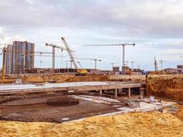 construção de uma nova área residencial no centro da cidade. para a construção de edifícios de vários andares, existem guindastes de grande altura. carregando grandes cargas foto