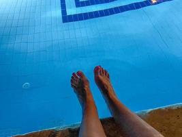 vista dos pés masculinos descalços ao lado da piscina foto