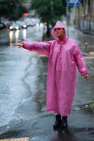 jovem tentando parar um táxi. mulher chamando um táxi em um dia chuvoso. foto