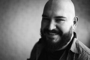 retrato de um homem careca em uma camisa com barba foto