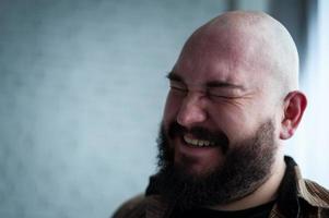 retrato de um homem careca em uma camisa com barba foto