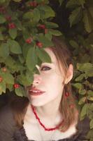 close-up mulher espreitando através de retrato de folhas de winterberry foto