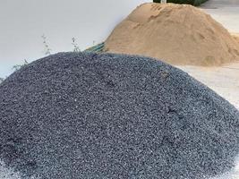 uma pilha de pedra britada e uma pilha de areia no canteiro de obras. foto