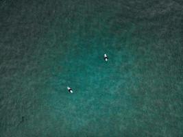 surfistas na praia unstad nas ilhas lofoten na noruega foto