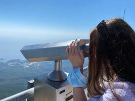 mulher de férias olhando através de binóculos foto