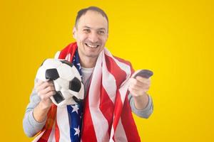 fã de futebol com uma bola amassada deformada e uma bandeira americana foto