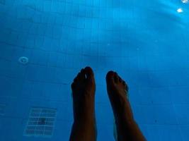 pernas de homem na piscina para relaxar foto
