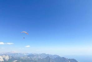 pára-quedistas voam pelo ar. saltar para baixo em um parapente. vista da cidade de uma altura de vôo. recreação ativa, entretenimento extremo foto