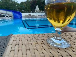um copo de cerveja em um dia ensolarado à beira da piscina foto