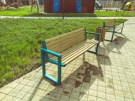 banco de madeira no parque na rua. recreação de pessoas ao ar livre. assentos feitos de materiais naturais para o descanso de turistas cansados foto