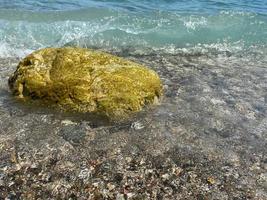 salpicos de água do mar em rochas isoladas em um fundo azul escuro foto