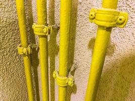 radiador para fornecer aquecimento a apartamentos residenciais. tubo de bateria amarelo para abastecimento de água quente. encanamento em um prédio residencial foto