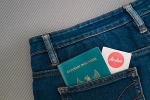 indonésia em julho de 2022. um passaporte indonésio e um cartão de embarque das companhias aéreas filipinas no bolso da calça jeans. foto